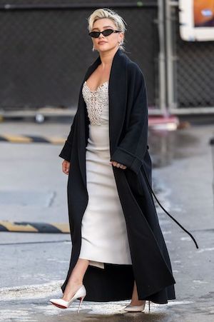 florence pugh paparazzi photo of her wearing a long black trench coat over a dress and sunglasses