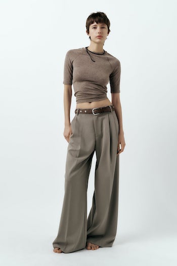 a model wearing a brown top and brown trousers with a brown belt